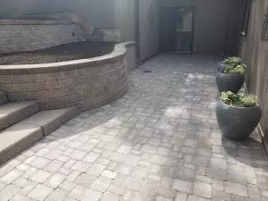 Brick paver patio with walkout access and retaining wall