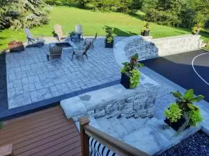 Elevated stamped concrete patio with custom fire pit and ledge stone steps