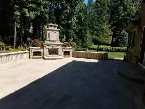 Brick paver backyard patio with retaining seat wall and brick fireplace