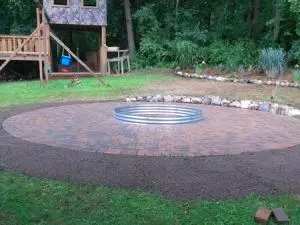 Metal ring fire pit with round paver patio surround