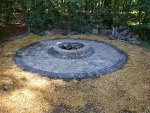 Brick fire pit with metal ring and round paver patio