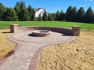 Brick fire pit with metal ring, paver patio surround and walkway and seating retaining wall