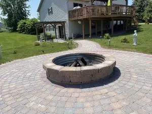 Brick fire pit with metal ring anbd round paver patio surround