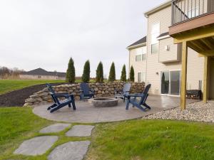 Custom paver patio with flagstone walkway, fire pit, and boulder retaining wall